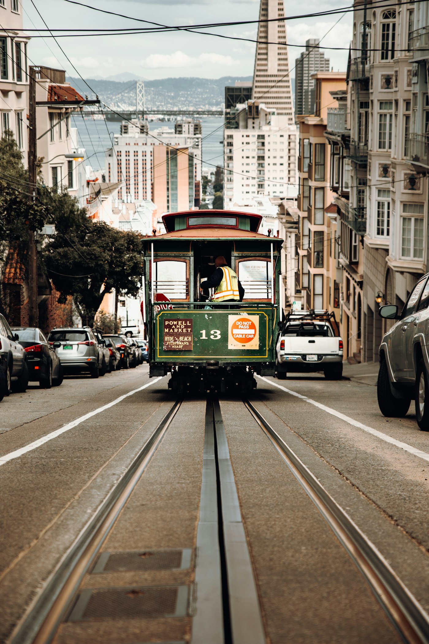 A cable car on California Street in San Francisco with the Transamerica Pyramid behind