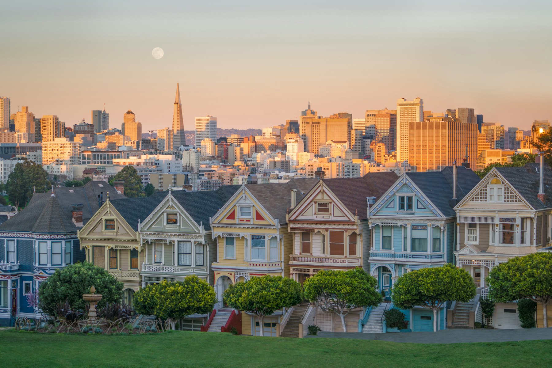 The Painted Ladies Victorian houses at Alamo Square with the San Francisco skyline at dusk
