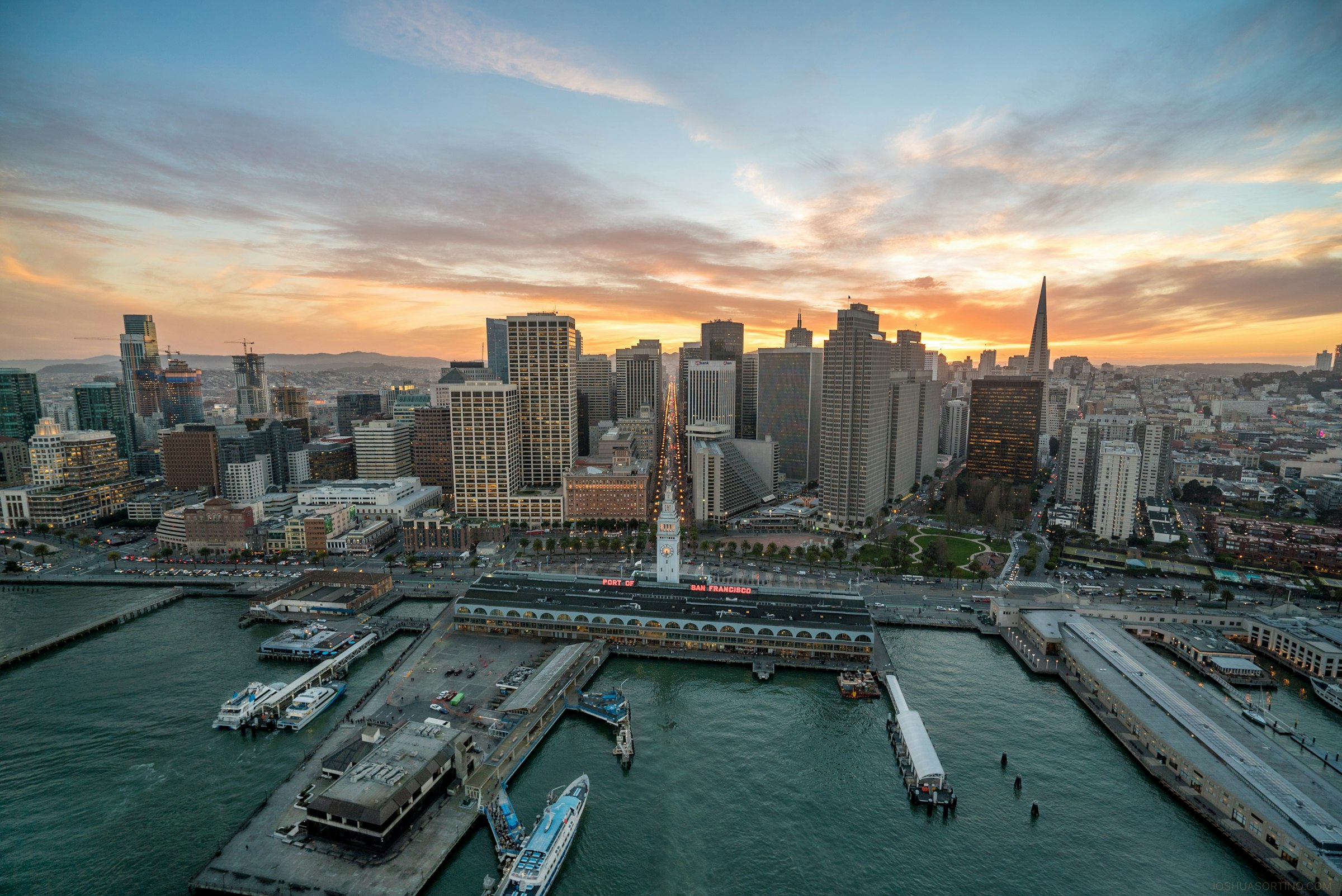 Aerial view of the San Francisco waterfront and downtown skyline at sunset